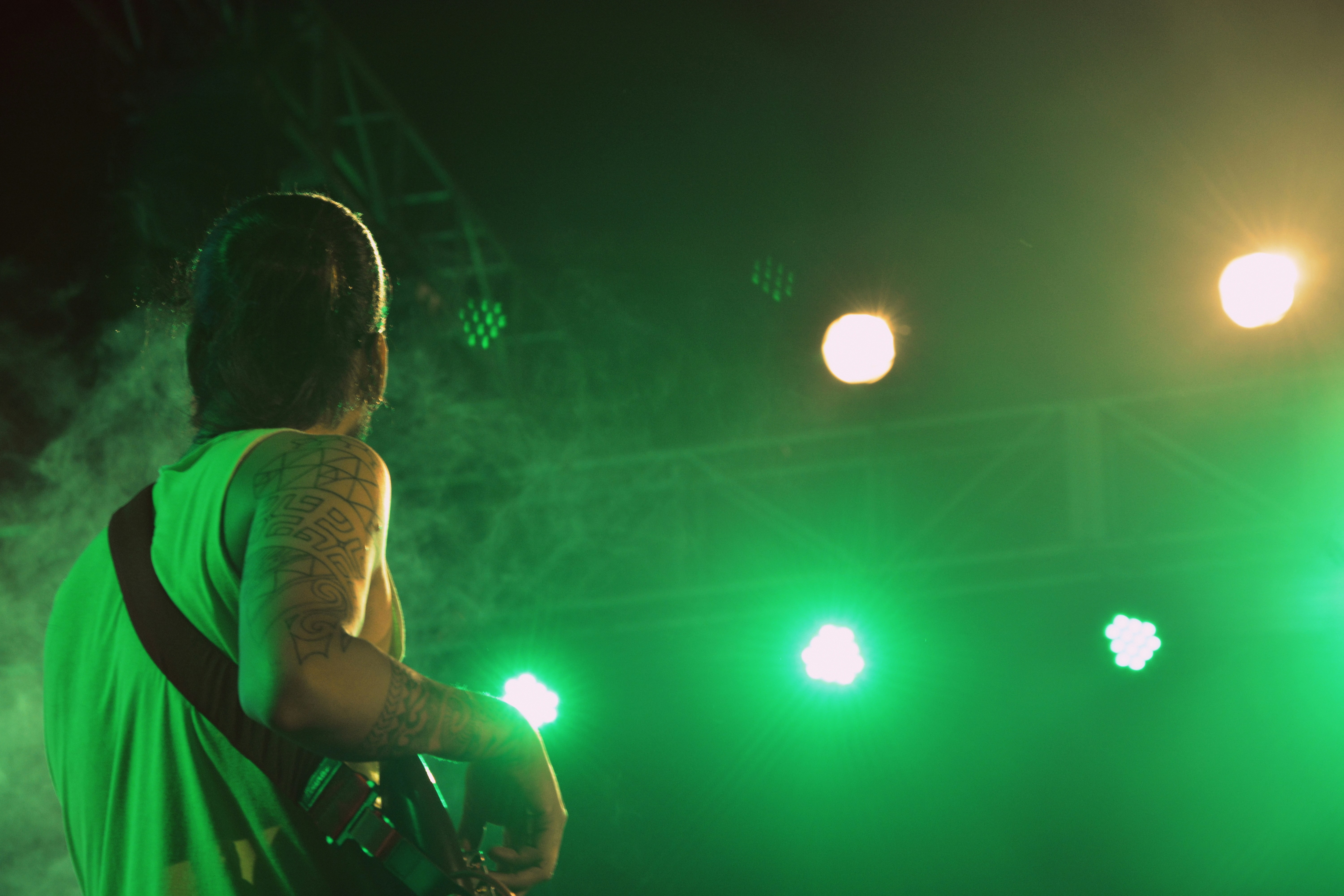 Musikerin mit E-Gitarre vor grünem Licht