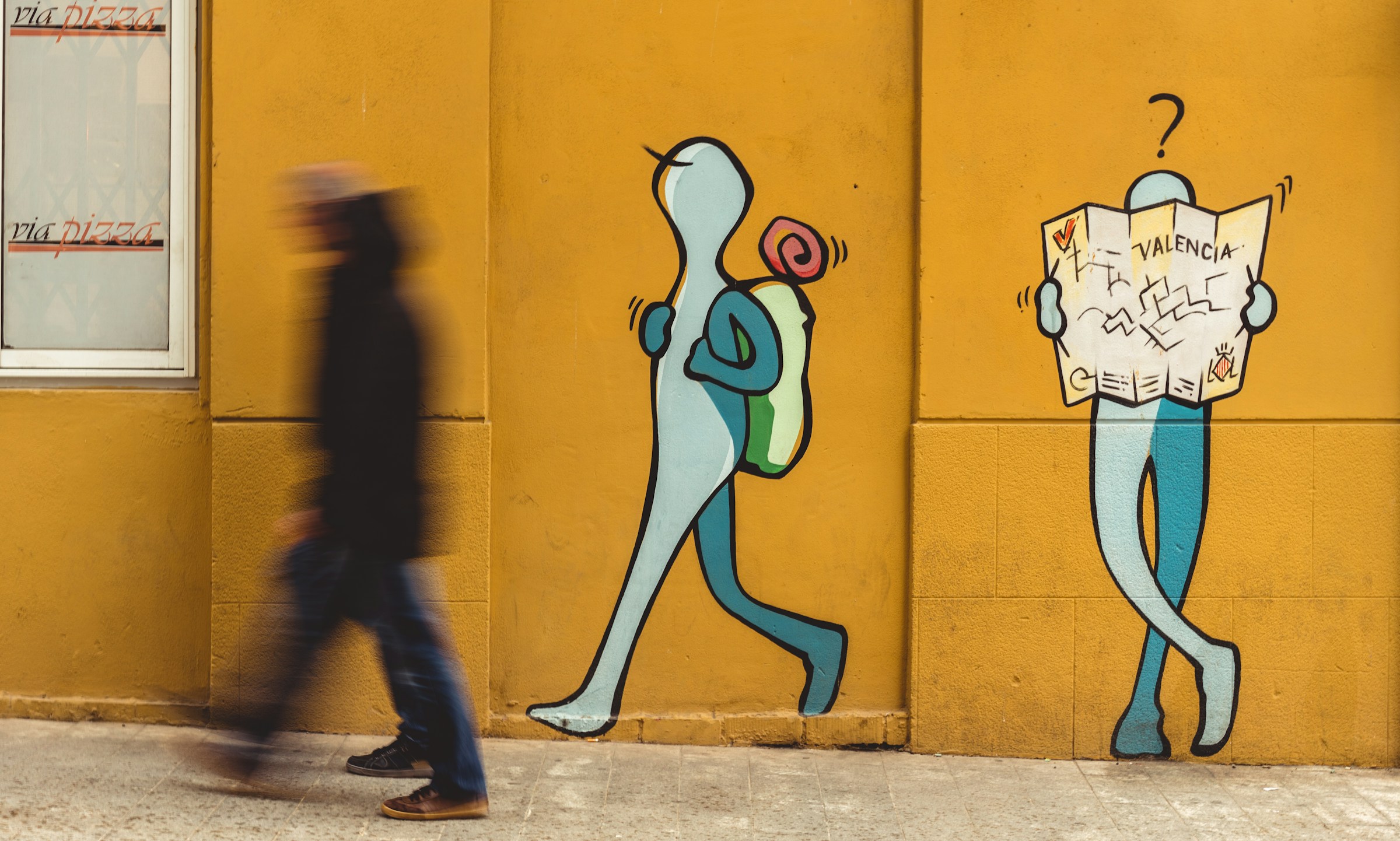 Menschen gehen an einem Graffiti vorbei