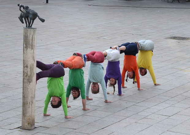 Personen im Handstand in einer Reihe
