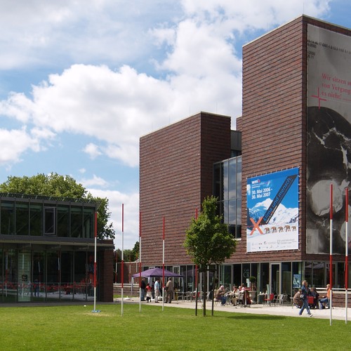 Modernes Gebäude vor teilweise bewölktem Himmel.