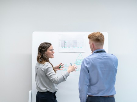 Zwei Menschen reden vor einem Diagramm