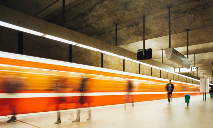 Ein U-Bahn fährt an einem Bahnsteig vorbei.