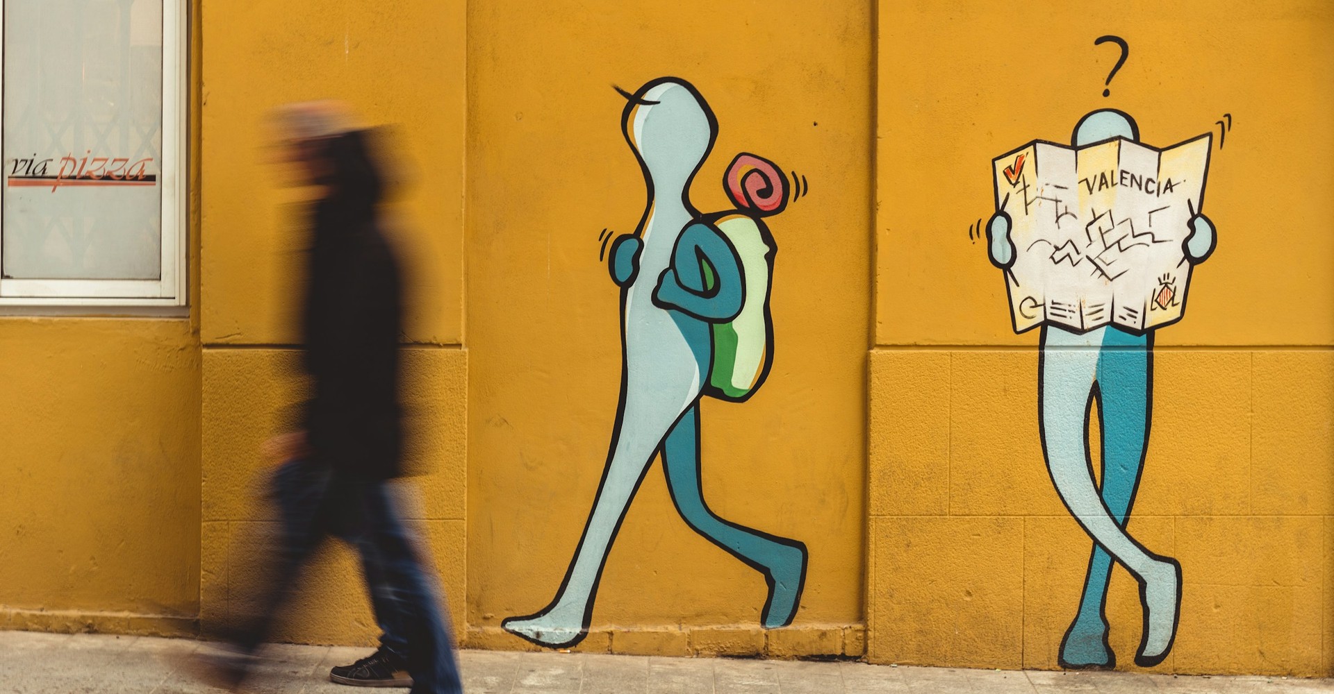 Menschen gehen an einem Graffiti vorbei