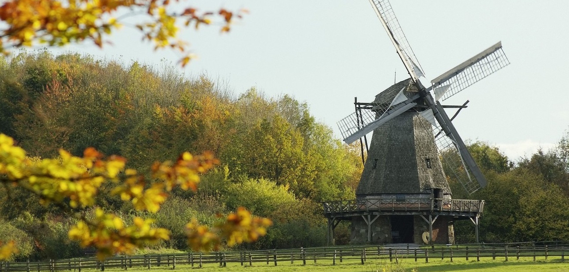 Eine Windmühle in einer herbstlichen Landschaft.