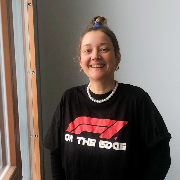 Junge lächelnde Frau mit Pullover mit Aufschrift "on the edge"