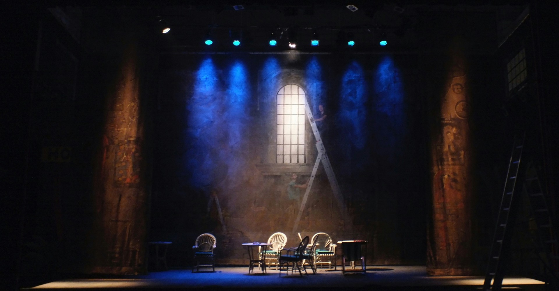 Theaterbühne mit leeren Stühlen, farbig angestrahlter Nebel sorgt für Atmosphäre